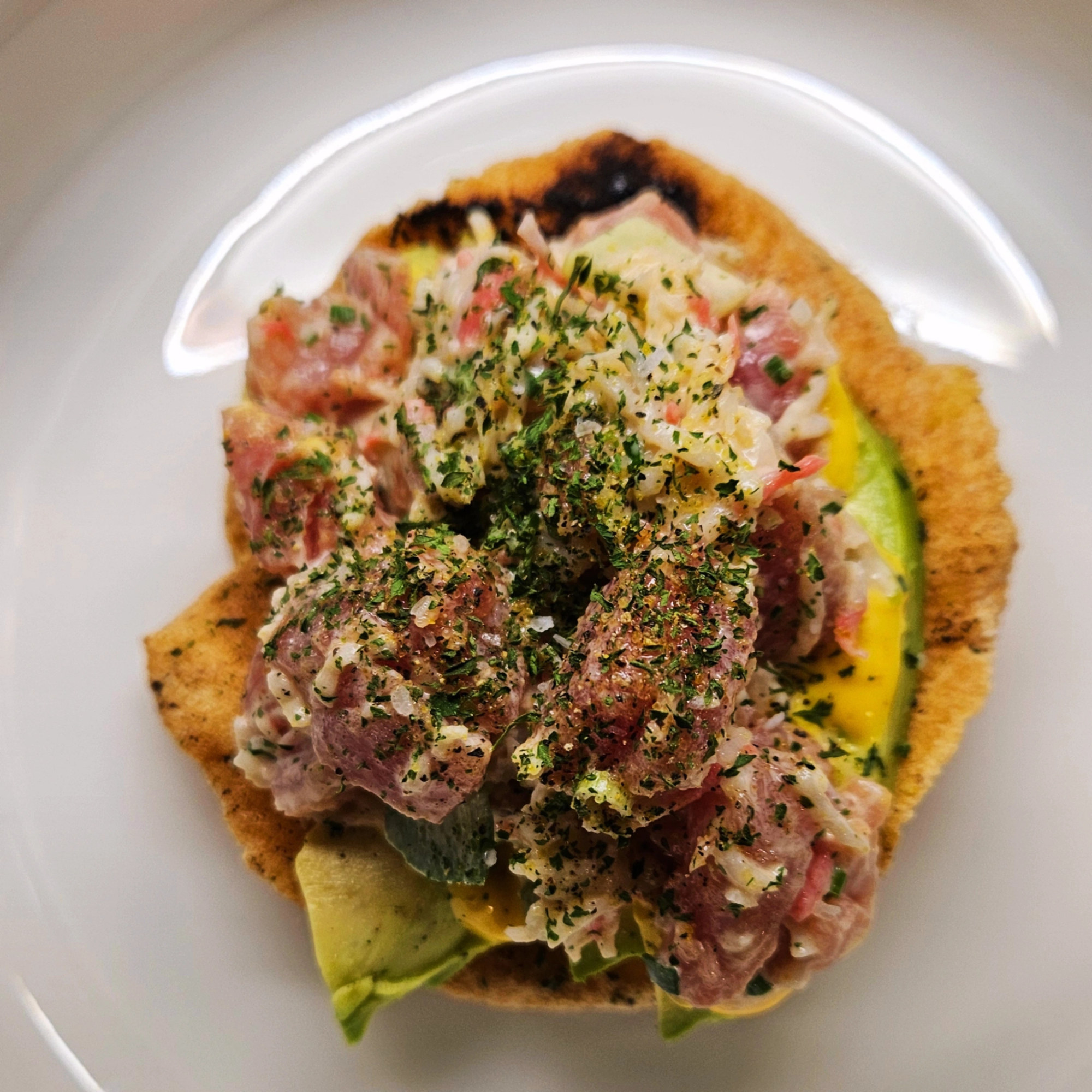 Close-up of plated food with rich textures and layered garnishes
