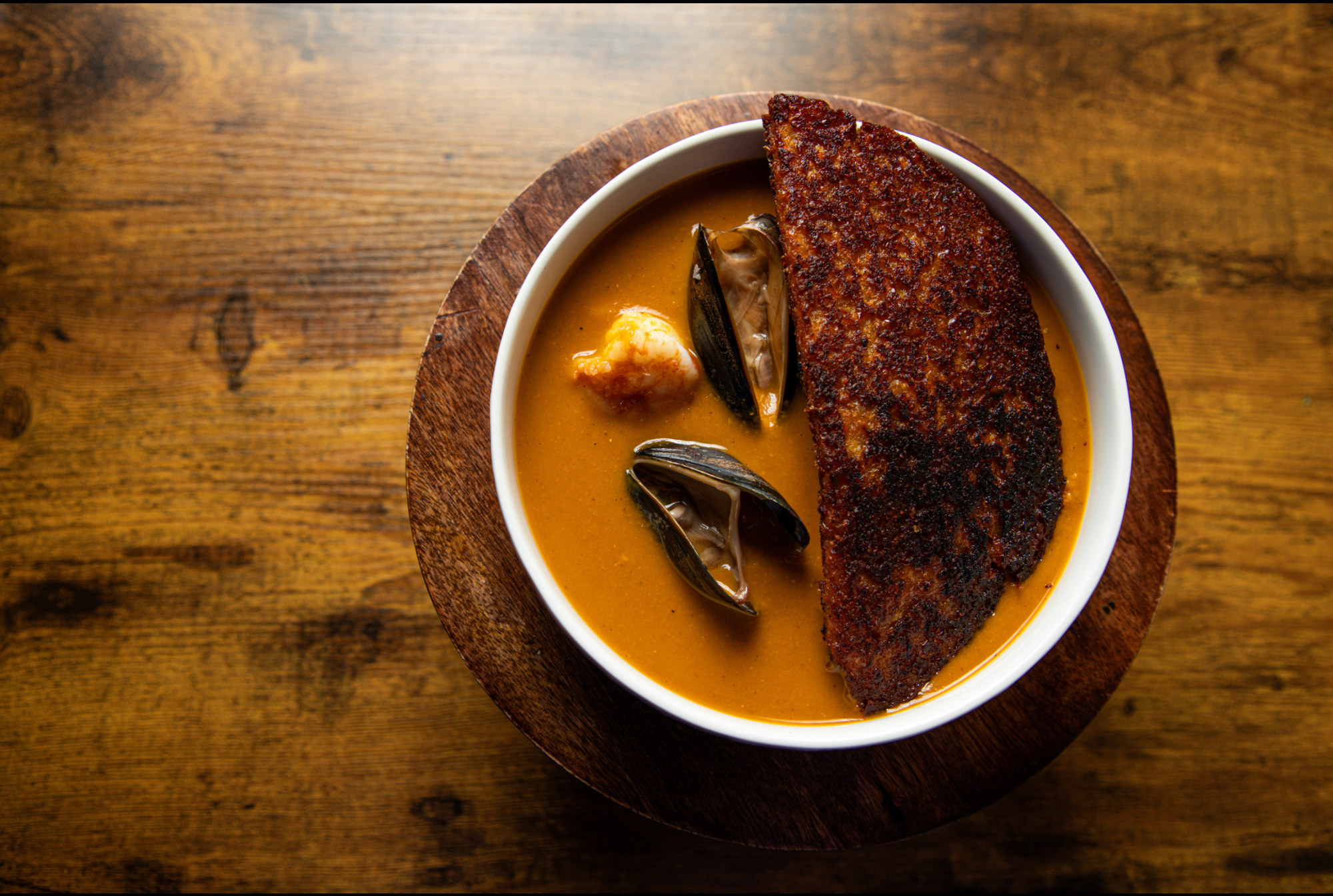 Minimalist plated fish with orange sauce and wooden tabletop